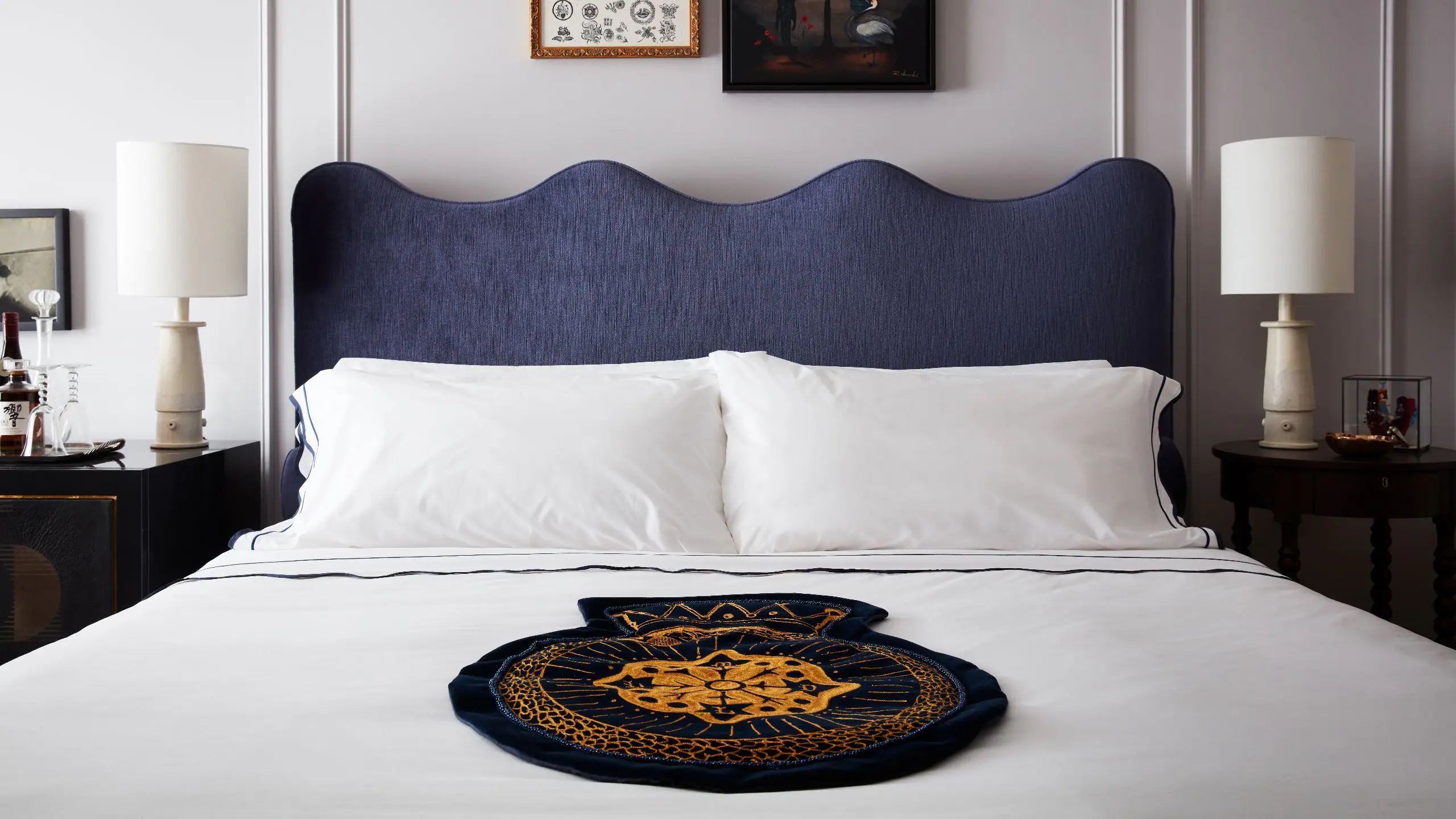 a bed with a blue headboard and white sheets